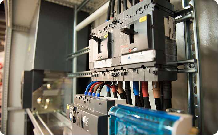 Détail d’un tableau électrique industriel avec disjoncteurs et câblage de puissance.