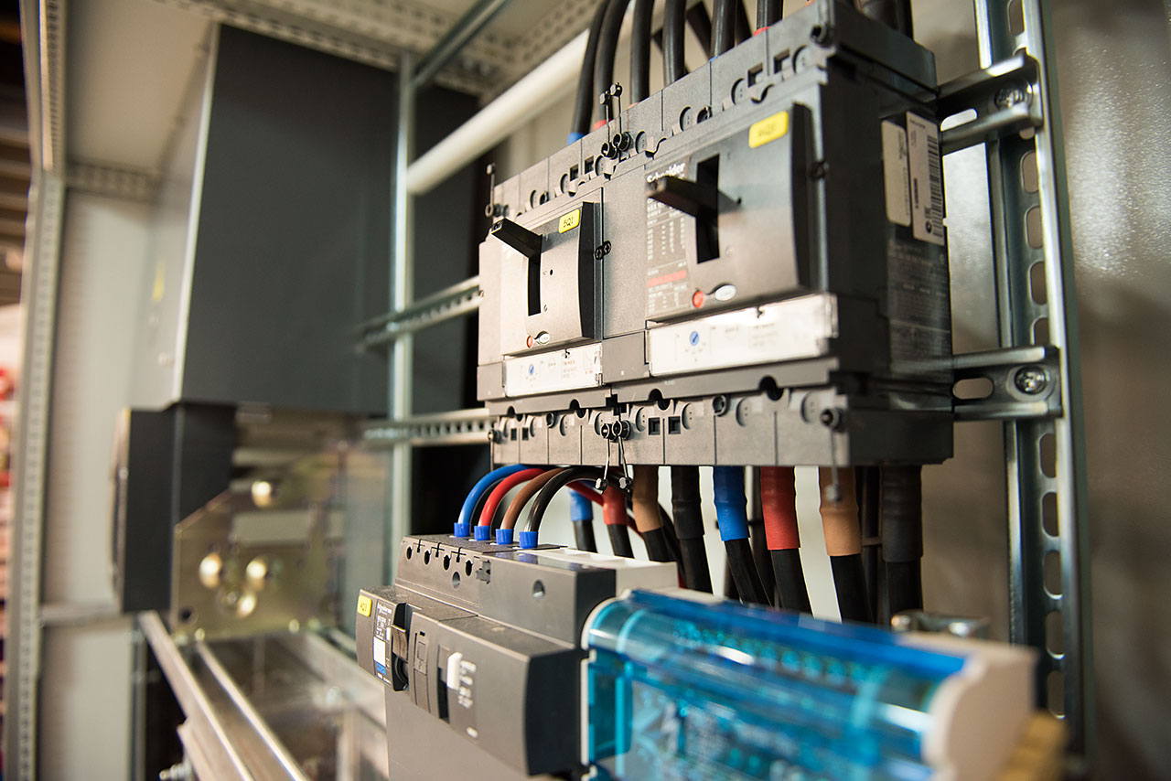 Tableau électrique industriel avec disjoncteurs et câblage pour installation professionnelle.